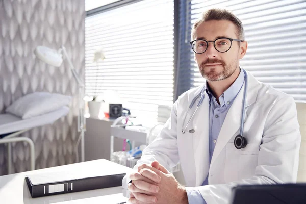 Portrét Usmívajícího Mužského Doktora Bílým Kabátem Stetoskoborem Sedět Stolem Kanceláři — Stock fotografie