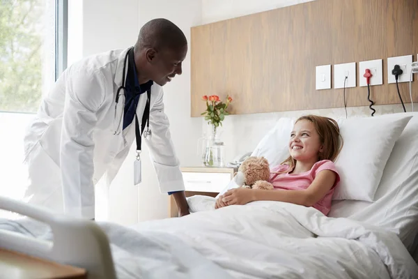 Hombre Doctor Visitando Chica Acostado Hospital Cama Abrazando Oso Peluche — Foto de Stock