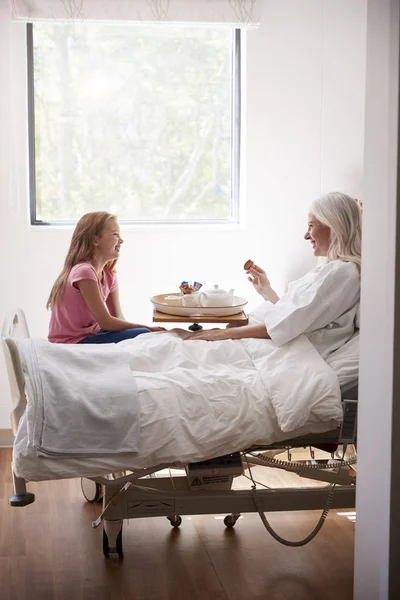 Εγγονή Επίσκεψη Γιαγιά Στο Νοσοκομείο Κρεβάτι Για Απογευματινό Τσάι — Φωτογραφία Αρχείου