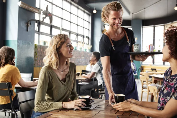 Dos Amigas Sentadas Mesa Cafetería Siendo Atendidas Por Camarero — Foto de Stock