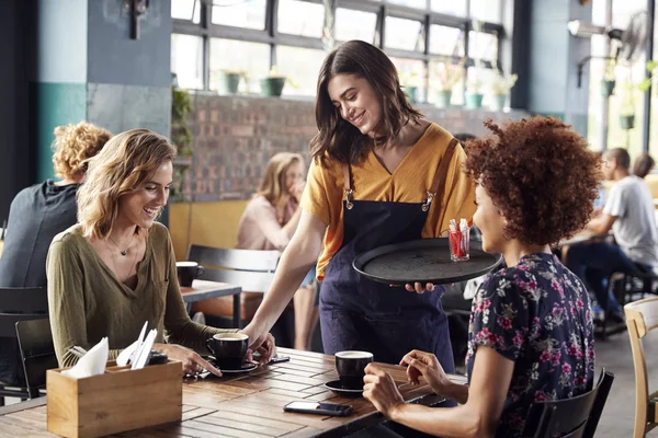 Twee Vrouwelijke Vrienden Zittend Aan Tafel Coffeeshop Wordt Bediend Door — Stockfoto