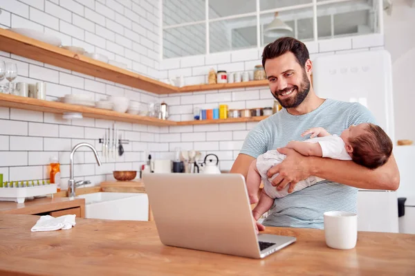 Multitasking Vater Hält Schlafenden Baby Sohn Und Arbeitet Küche Laptop — Stockfoto