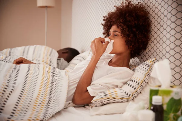 Milenial Mujer Afroamericana Sentada Cama Sonándose Nariz Pareja Dormida Fondo — Foto de Stock