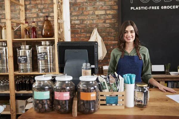 セールスデスクの背後にある持続可能なプラスチックフリー食料品店の女性オーナーの肖像 — ストック写真