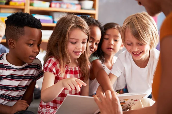 Groep Basisschoolleerlingen Zittend Vloer Luisteren Naar Vrouwelijke Leraar Lezen Verhaal — Stockfoto