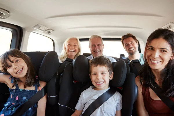 三代白人家庭坐在汽车两排乘客座椅上 微笑着对着镜头 — 图库照片