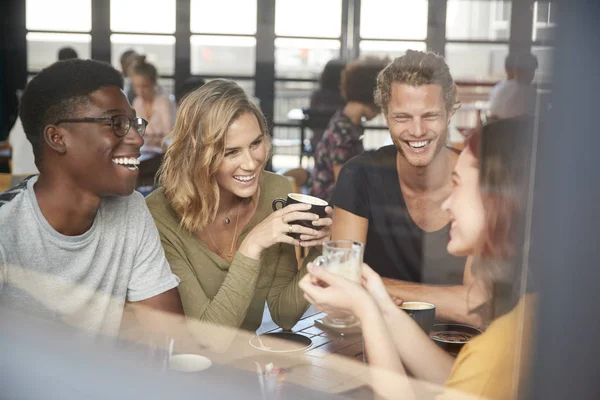 Groep Vrienden Zittend Aan Tafel Drukke Coffeeshop Praten — Stockfoto