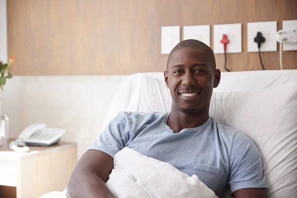 病院のベッドに横たわる男性患者の肖像画カメラに微笑む — ストック写真