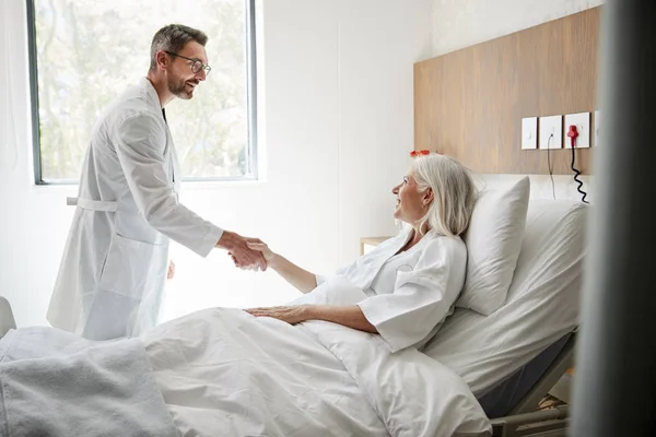 Sebész Látogatás Kézfogás Érett Női Beteg Kórházi Ágyban — Stock Fotó