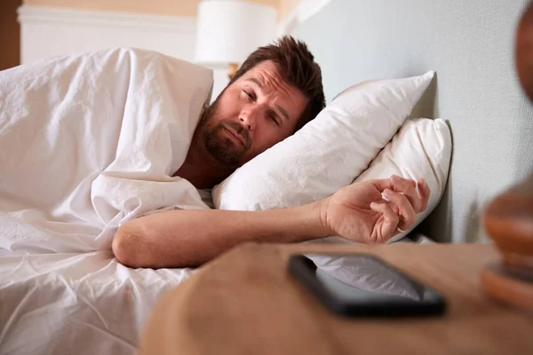 Mid Adult Man Asleep Bed Looking Smartphone Bedside Table Foreground — Stock Photo, Image