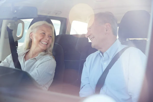 お互いに微笑み合う車の中で運転する幸せなシニア白人カップル フロントフロントガラスを通して見た — ストック写真