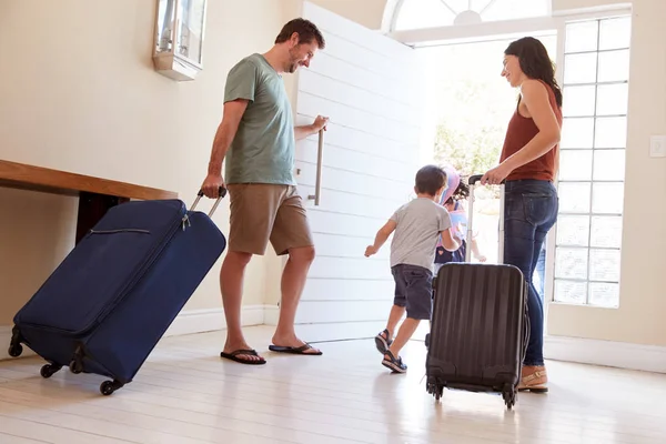 ミッド大人の白いカップルと子供は休暇に行くために荷物を持って家を出て フルレングス — ストック写真
