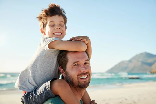 年长成年白人男子在沙滩上与四岁的儿子在他的肩膀 看着相机 — 图库照片