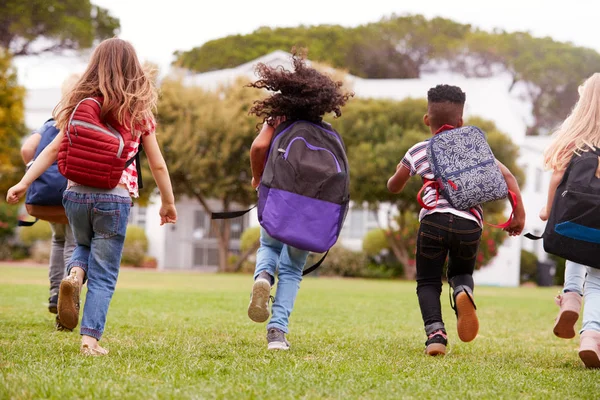 Bakifrån Grundskoleelever Som Springer Över Fält Vid Rasttid — Stockfoto