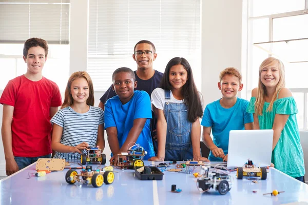 放課後コンピュータコーディング教室でロボット車両を構築する教師を持つ生徒の肖像 — ストック写真