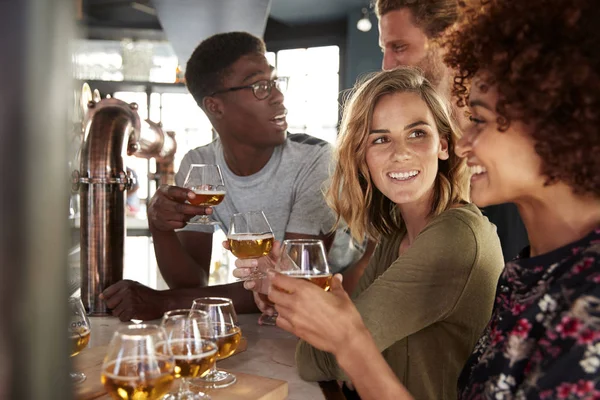 一群朋友品尝啤酒坐在酒吧 — 图库照片