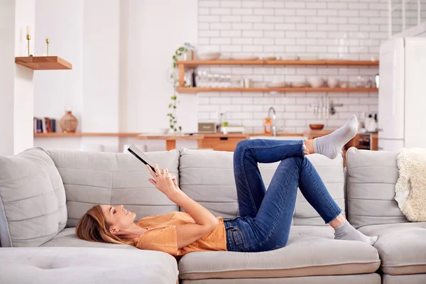 Kobieta Relaks Leżąc Kanapie Domu Patrząc Cyfrowy Tablet — Zdjęcie stockowe