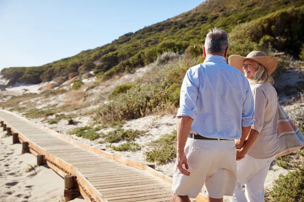 Senior Vita Paret Går Längs Trä Promenad Strand Håller Händer — Stockfoto