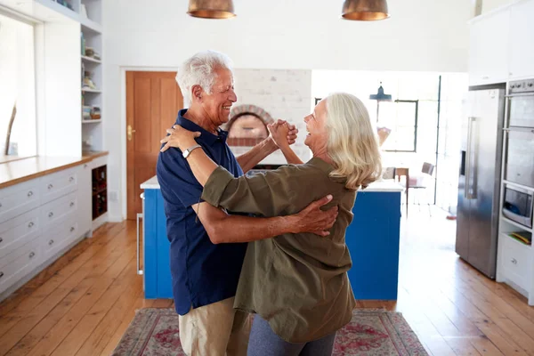 一緒にキッチンで踊る自宅でシニアカップル — ストック写真