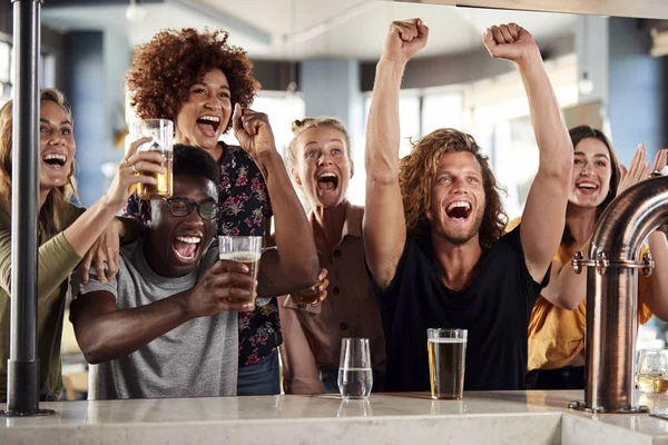 Grupo Amigos Masculinos Femininos Comemorando Enquanto Observam Jogo Tela Barra — Fotografia de Stock