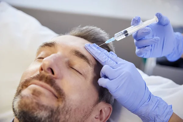 Kvinnlig Kosmetolog Ger Mogna Manliga Patienten Botox Injektion Pannan — Stockfoto