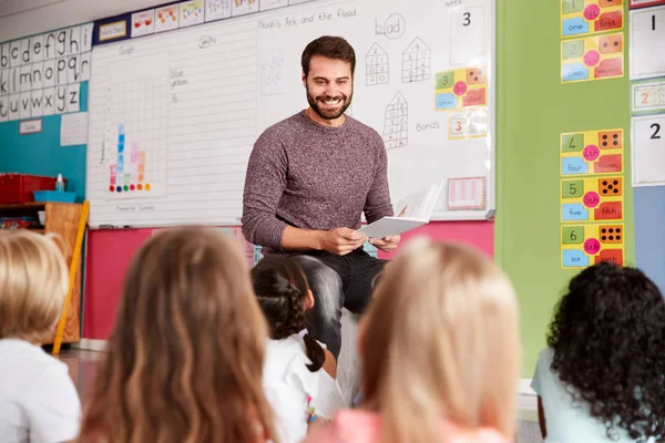 Manlig Lärare Läser Historia Till Grupp Elementära Elever Skolan Klassrum — Stockfoto