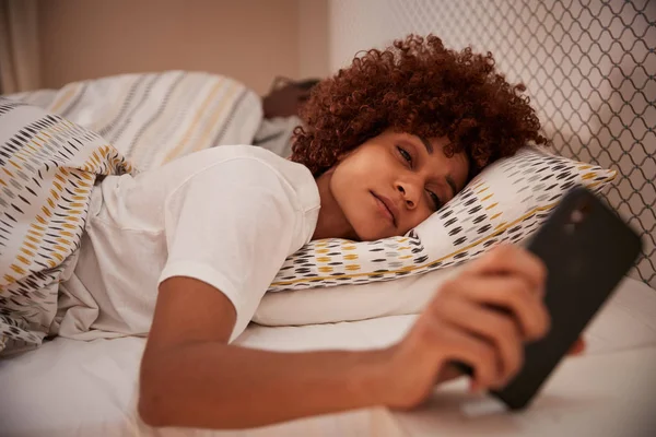 Milenial Mujer Afroamericana Medio Dormida Cama Mirando Teléfono Inteligente Cerca —  Fotos de Stock