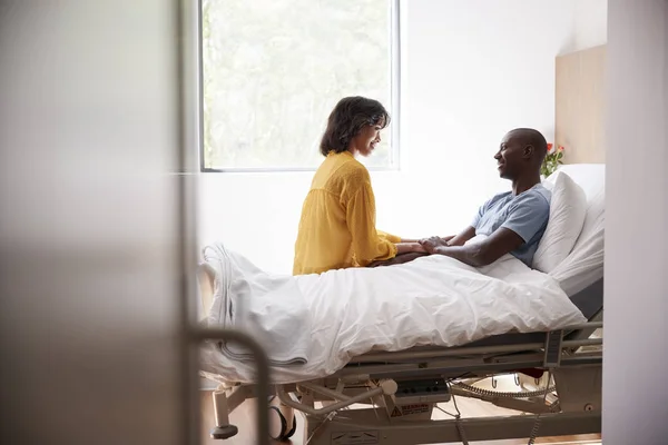 Vrouw Een Bezoek Praten Met Geduldig Man Ziekenhuis Bed — Stockfoto