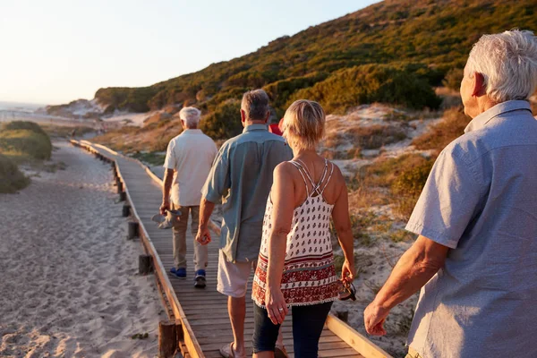 Grupa Starszych Przyjaciół Chodzenie Wzdłuż Boardwalk Plaży Lato Grupa Wakacje — Zdjęcie stockowe