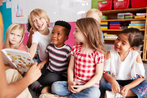 Gruppe Von Grundschülern Sitzt Auf Dem Boden Und Hört Einer — Stockfoto