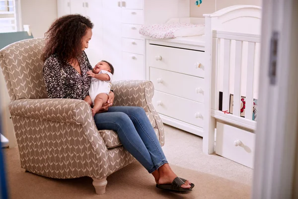 慈爱的母亲坐在椅子上抱着婴儿儿子在家里的托儿所 — 图库照片