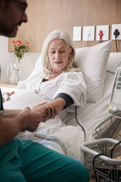 Male Nurse Taking Mature Female Patients Blood Pressure Hospital Bed — Stock Photo, Image