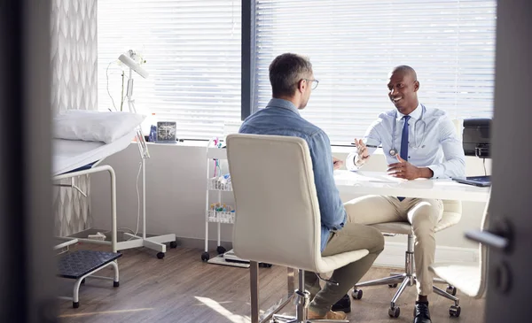 オフィスで医師と相談する成熟した男性患者 — ストック写真