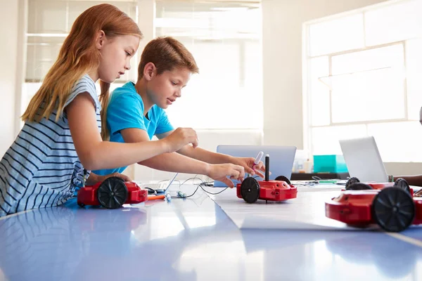 放課後の2人の学生がロボット車両をプログラムするコンピュータコーディング教室を学習 — ストック写真