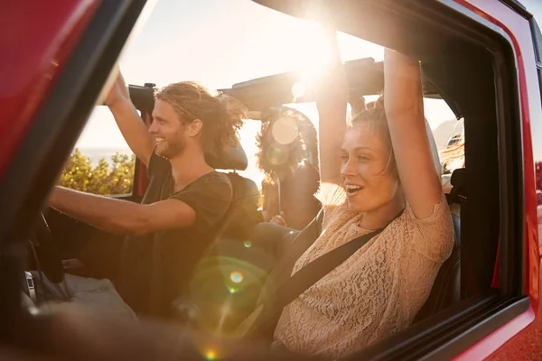 兴奋的千禧年朋友在公路旅行度假驾驶在一辆敞车 镜头耀斑 — 图库照片