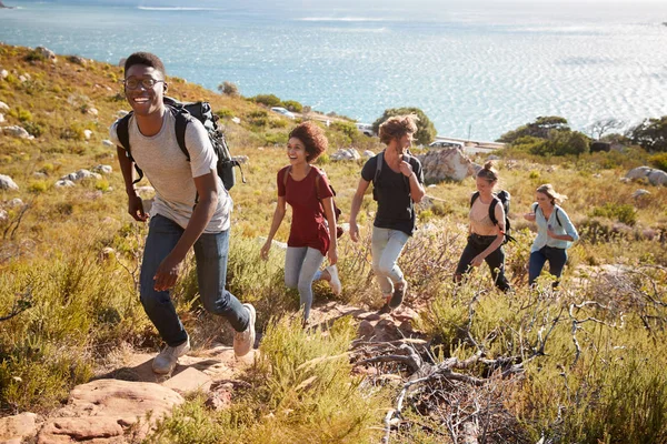 Happy Young Adult Friends Hiking Single File Uphill Path Coast — Stock Photo, Image