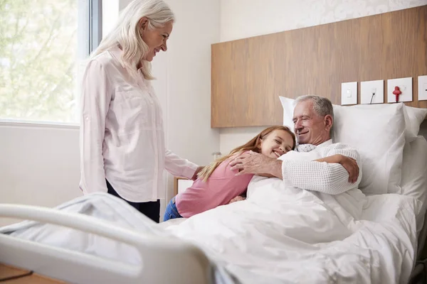 孙女拥抱祖父在家庭医院访问 — 图库照片