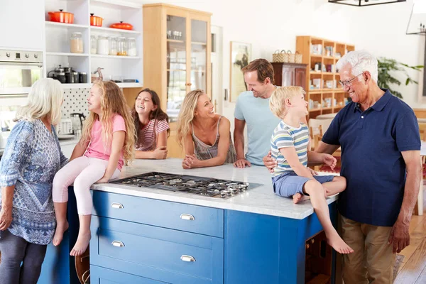 Multi-Generation Family Standing Around Kitchen Island Together