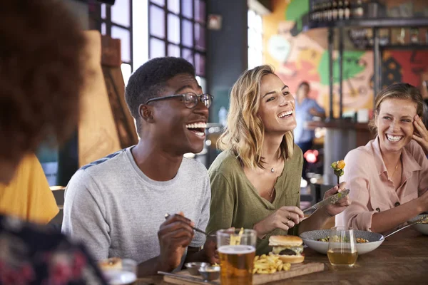 一群年轻朋友在餐厅享用饮料和食物 — 图库照片