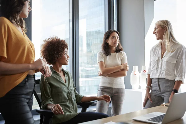 クリエイティブオフィスのデスクで4人の女性同僚がディスカッション 3四半期の長さ クローズアップ — ストック写真
