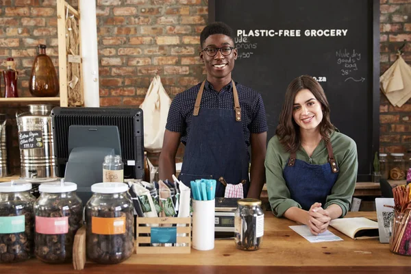 セールスデスクの背後にある持続可能なプラスチックフリー食料品店の男性と女性の所有者の肖像 — ストック写真