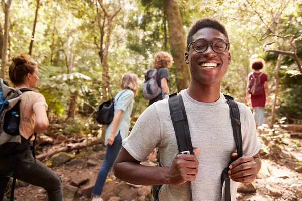 腰部向上的千禧年非洲裔美国人与朋友在森林中徒步旅行的肖像 — 图库照片