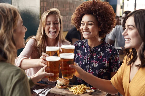 Reunião de quatro jovens amigas para bebidas e alimentos fazendo um T — Fotografia de Stock