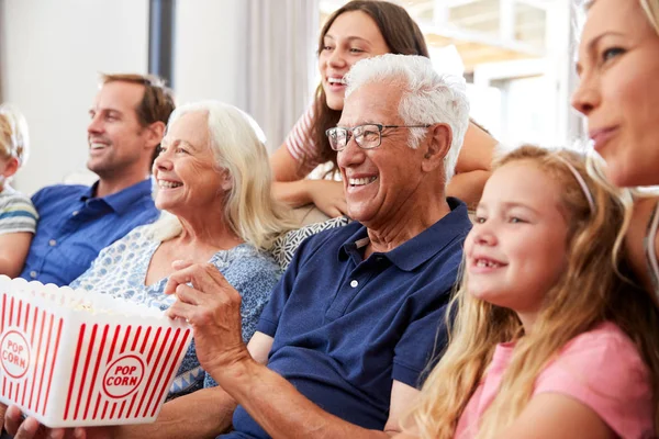 Mehrgenerationenfamilie Sitzt Hause Auf Sofa Isst Popcorn Und Guckt Gemeinsam — Stockfoto