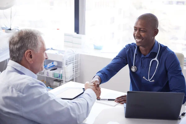 Paciente Masculino Mayor Agitando Las Manos Con Médico Sentado Escritorio — Foto de Stock