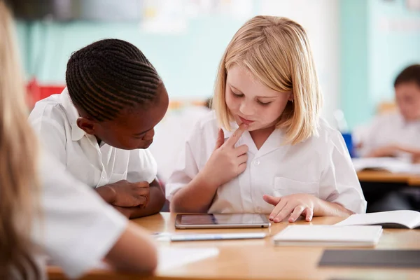 책상에서 디지털 태블릿을 사용하여 유니폼을 입고있는 초등학교 — 스톡 사진
