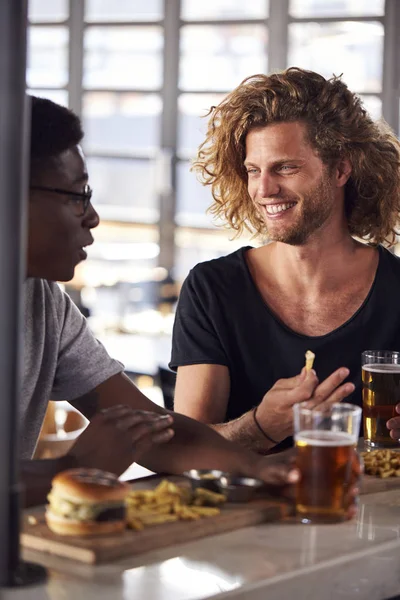 Dos Amigos Varones Comiendo Comida Bebiendo Cerveza Bar Deportivo —  Fotos de Stock
