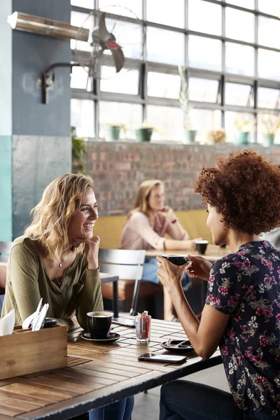 两位女性朋友会议坐在餐桌上在咖啡店和谈话 — 图库照片