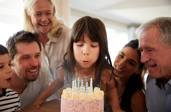 六岁的白人女孩吹出蜡烛的生日蛋糕上看她的家人看 — 图库照片