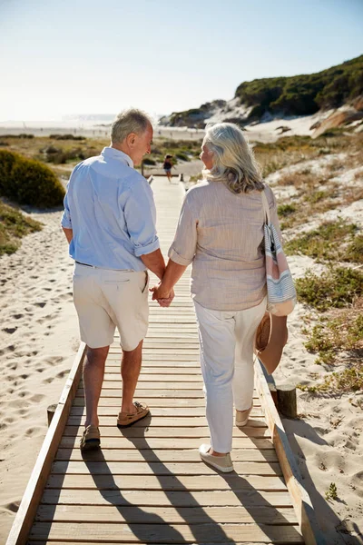 Casal Branco Sênior Andando Longo Calçadão Madeira Uma Praia Mãos — Fotografia de Stock